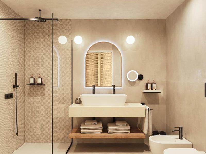 Modernes Badezimmer mit beiger Wand, bodengleicher Dusche, Waschbecken, Spiegel und zwei Toiletten.