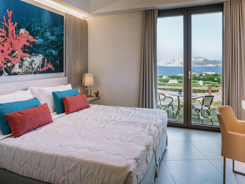 Hotelový pokoj se dvěma jednolůžky, velkým výhledem na moře přes okna od podlahy ke stropu a námořní výzdobou.