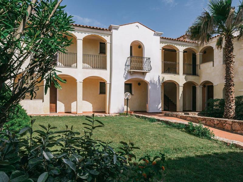 Dvoupodlažní hotel s středomořskou architekturou, balkonem, terasou a udržovanou zahradou.