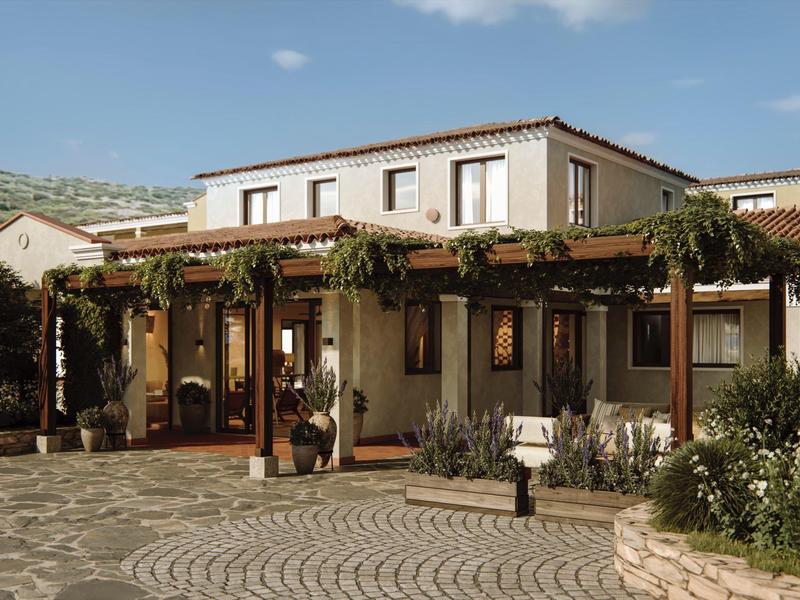 Vstupní část středomořského hotelu s pergolou a popínavými rostlinami.