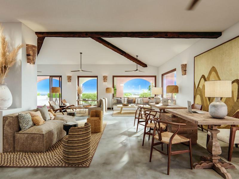 Světlý, elegantní hotelový salonek se sezením, dřevěným nábytkem a výhledem na moře a ostrov.