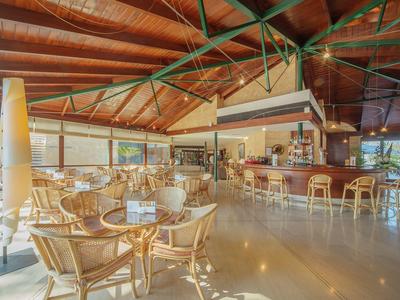 Großes, sonnendurchflutetes Restaurant mit Holzmöbeln, hohen Decken und vielen Sitzplätzen.