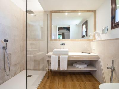 Moderne badkamer met inloopdouche, grote spiegel, zwevend wastafelkastje en houten vloer.