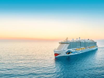 Ein großes Kreuzfahrtschiff gleitet auf ruhigem Meer bei Sonnenuntergang.