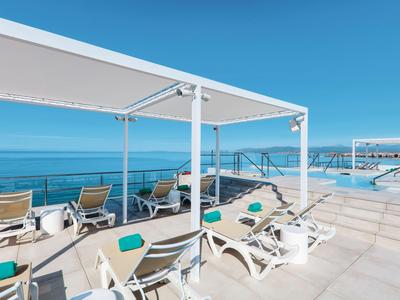 Terrazza solarium con lettini vista mare in una giornata di sole.