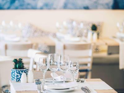 Elegantní restaurace s bílými prostřenými stoly a stylovou stolní výzdobou.