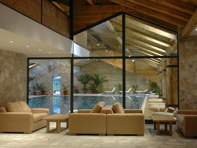 Innenansicht eines stilvollen Sitzbereichs mit Ledersofas und Glaswand mit Blick auf Innenhof.