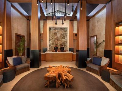 Elegante Lounge mit Holzmöbeln, warmen Beleuchtung und einem kunstvollen Baumstumpf-Tisch.