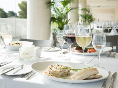 Elegancka restauracja z białymi stolikami i podanymi potrawami oraz napojami.