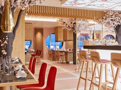 Intérieur moderne de restaurant avec sièges rouges et décorations florales.