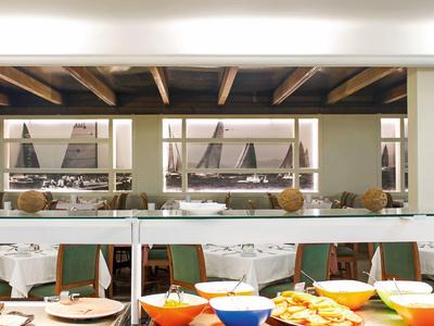 Área de buffet con variedad de comidas y asientos en un restaurante moderno.