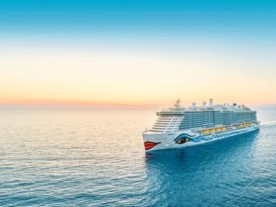 Large cruise ship sailing on calm sea during sunset with clear sky.