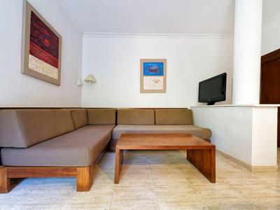 Cozy L-shaped brown cushioned sofa with wooden table in bright living area.