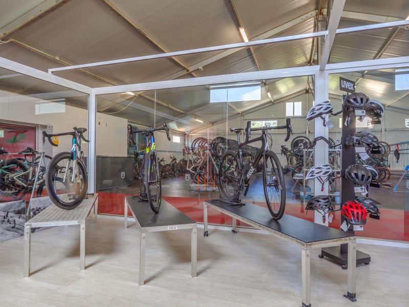 Intérieur avec plusieurs vélos sur des supports surélevés dans une pièce moderne et bien éclairée.