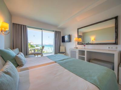 Helles Hotelzimmer mit Doppelbett, Meerblick und Zugang zu Balkon oder Terrasse.