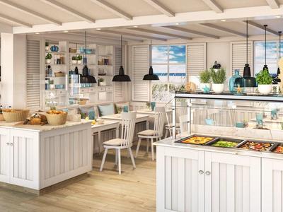 Bright hotel buffet area with white wooden counters and various food dishes under glass covers.