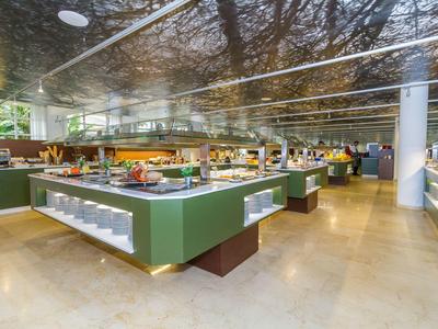 Modern buffet in a bright, spacious restaurant with green counters and a wide variety.