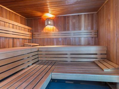 Interior of a Finnish sauna with multi-level wooden benches and wood paneling.