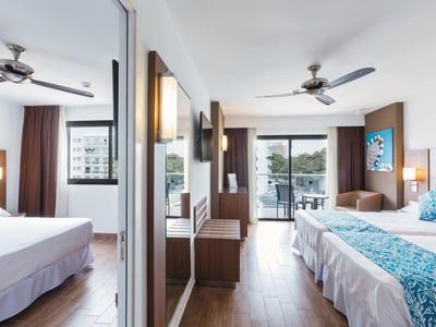 Nowoczesny pokój hotelowy z dwoma łóżkami, balkonem i eleganckim wystrojem.