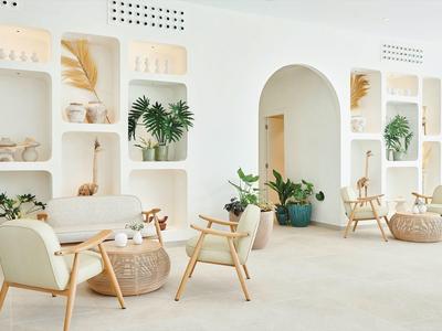 Camera d'hotel moderna e luminosa con scaffali curvi e decorazioni naturali.