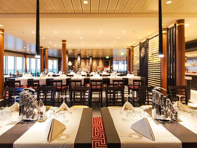 Un restaurant élégant avec des tables décorées festivement et des accents en bois modernes.