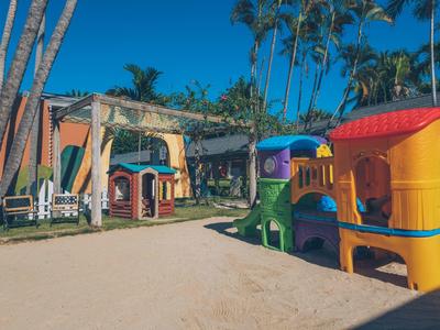 Area giochi colorata nella sabbia sotto le palme in un villaggio vacanze