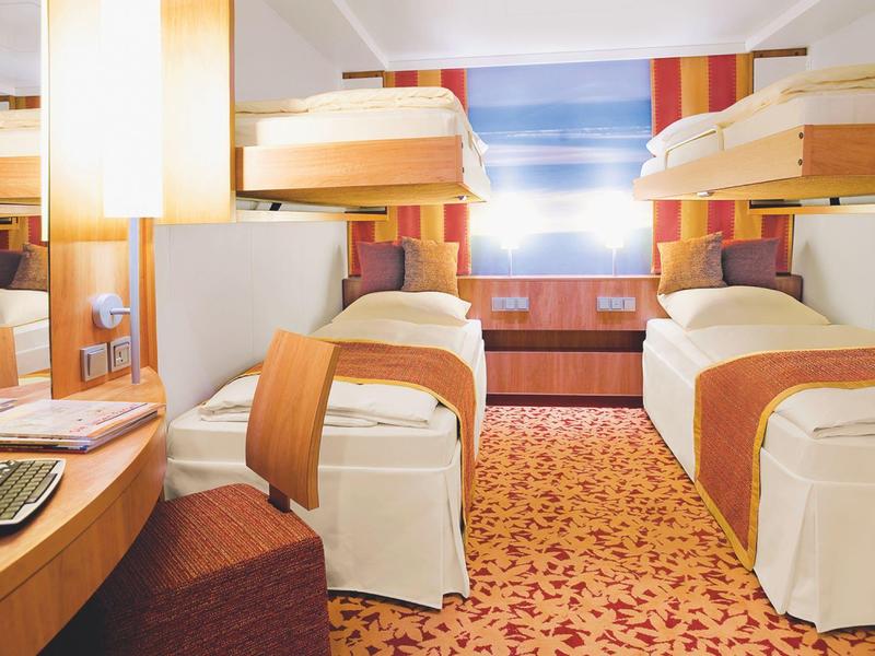 Camera d'hotel con due letti singoli, letti a castello, scrivania e moquette