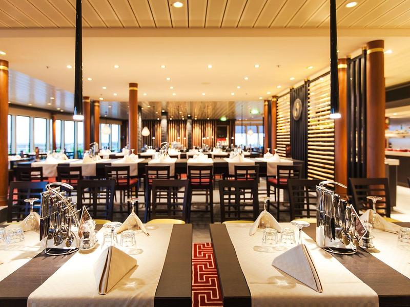 Restaurant élégant avec tables dressées et éclairage chaleureux.