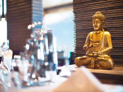 Statue de Bouddha dorée sur une table dans une pièce moderne et relaxante.
