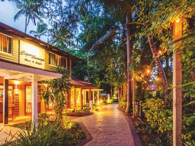 Beleuchteter Hotelweg am Abend mit üppiger tropischer Vegetation und Bäumen entlang des Pfads.