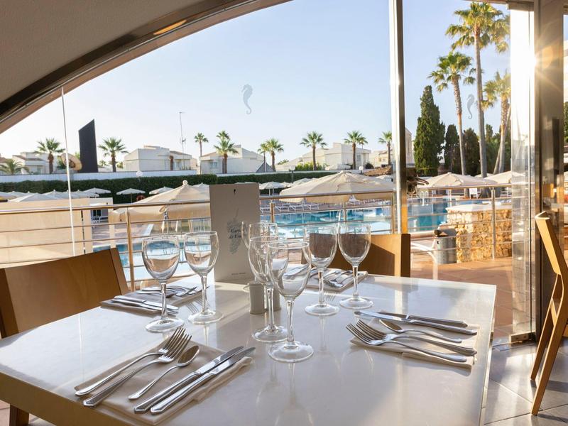 Eleganter gedeckter Tisch an einer Hotelterrasse mit Blick auf den Pool.
