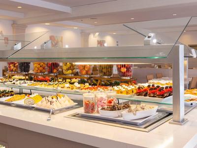 Buffet avec divers desserts, gâteaux et fruits dans un restaurant.