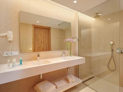 Salle de bain moderne avec douche à l'italienne, double lavabo et accessoires.