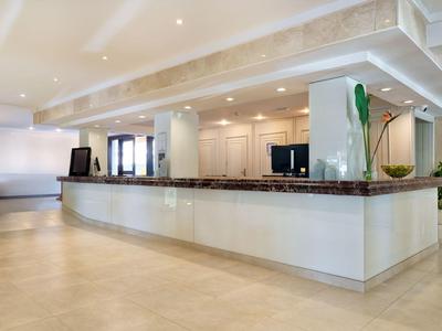 Modernes Badezimmer mit großer Spiegelwand, Waschtisch und begehbarer Dusche.