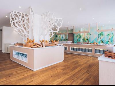 Bright, modern buffet area with wooden floors and white decorative elements.
