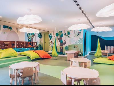 Sala giochi colorata per bambini con letti comodi e tavoli in un hotel