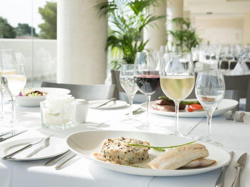 Elegancka restauracja z białymi stolikami i podanymi potrawami oraz napojami.