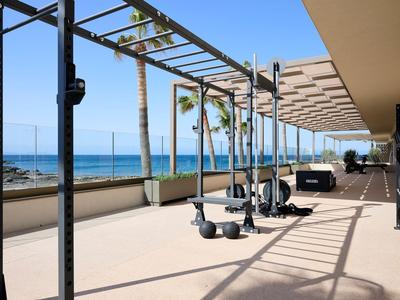 Area fitness all'aperto con attrezzi per esercizi e vista sul mare in una giornata di sole