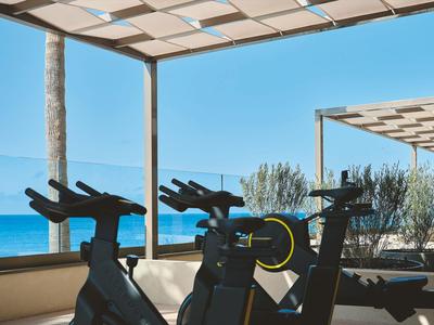 Area interna con cyclette fronte mare sotto una pergola moderna.