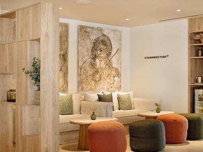 Cozy hotel lounge with modern seating and artwork on the wall.