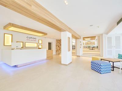 Bright, modern hotel lobby area with reception and seating in white and blue.