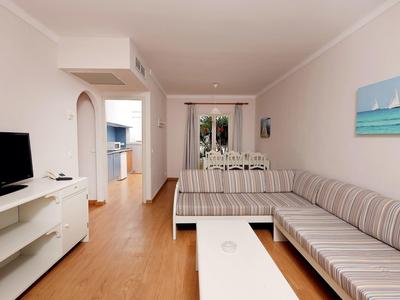 Modern ingericht woonkamer met bank, salontafel en tv in een vakantiewoning.