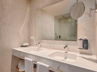 Modern bathroom with double sinks, large mirror, and minimalist decor.