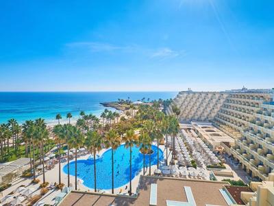Hôtel avec piscine près de la plage et de la mer sous un ciel bleu clair