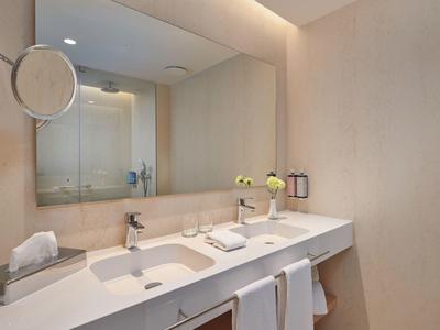 Modern hotel bathroom with large mirror and double sink.