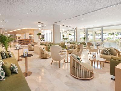 Bright, modern hotel lounge area with comfortable seating and large windows.