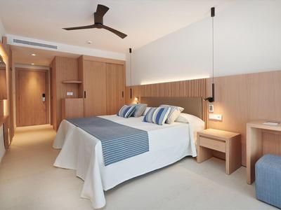 Moderne hotelkamer met groot bed, houten panelen en minimalistisch ontwerp.