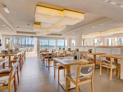 Licht, modern restaurant met houten meubels en grote ramen met uitzicht op de haven.