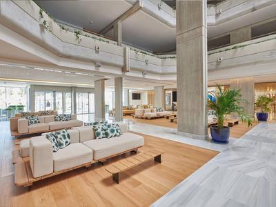 Geräumige Hotellobby mit modernen Sofas und vielen Fenstern für viel Tageslicht.