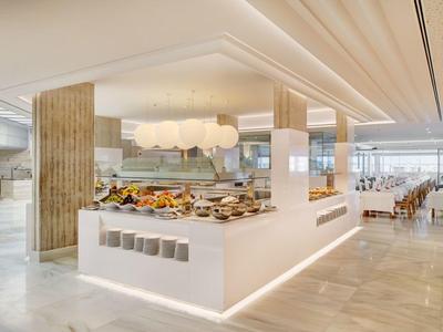 Modernes, helles Buffet mit vielfältigem Frühstück und elegantem Interieur in warmen Tönen.